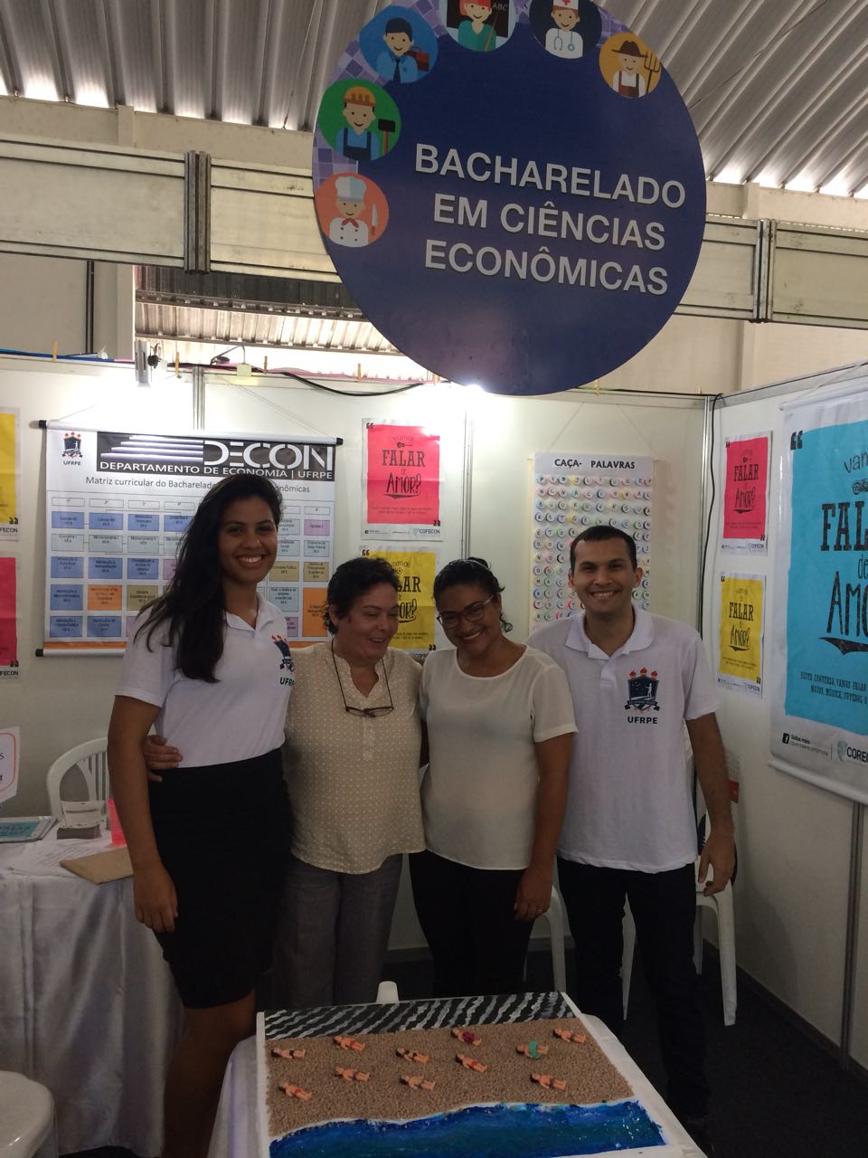 Profªs Isabel Oliveira e Eliane Abreu e monitores recepcionam visitantes no stand do DECON